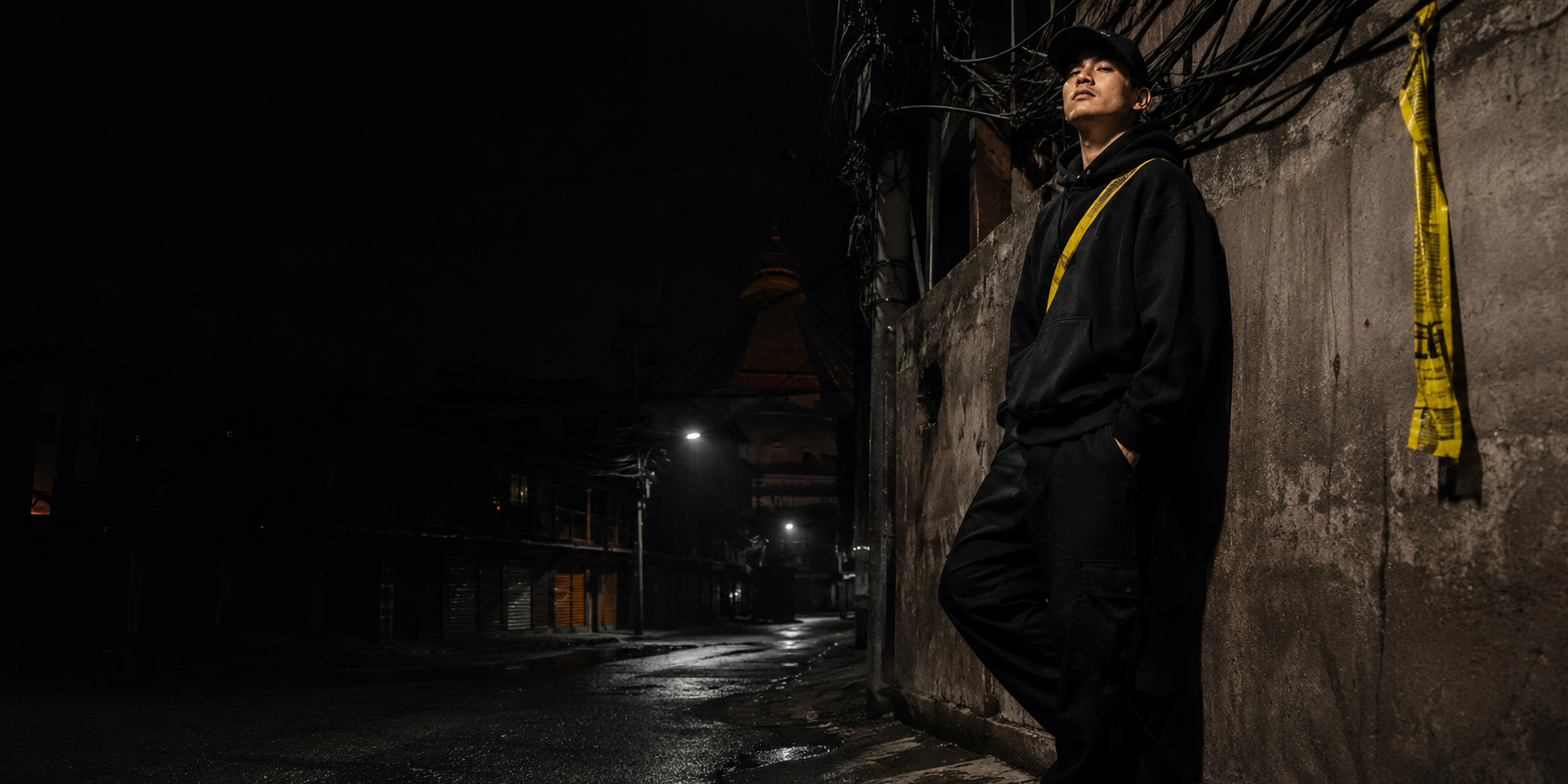 A figure in the rain-slicked backstreets of the city